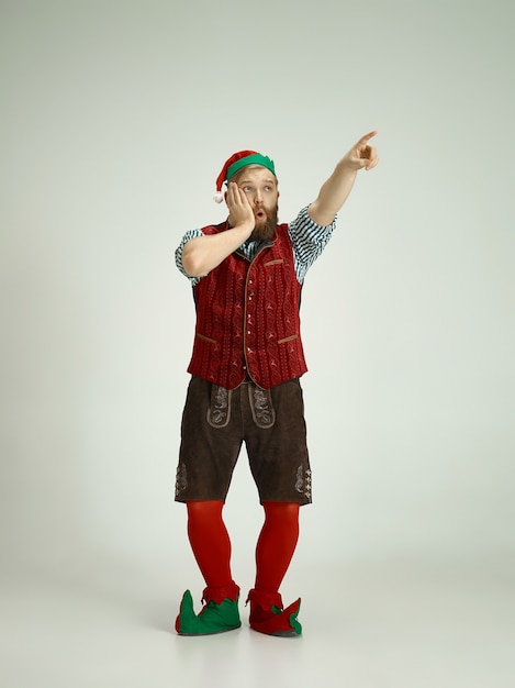 Free Photo friendly man dressed like a funny gnome posing on an isolated gray