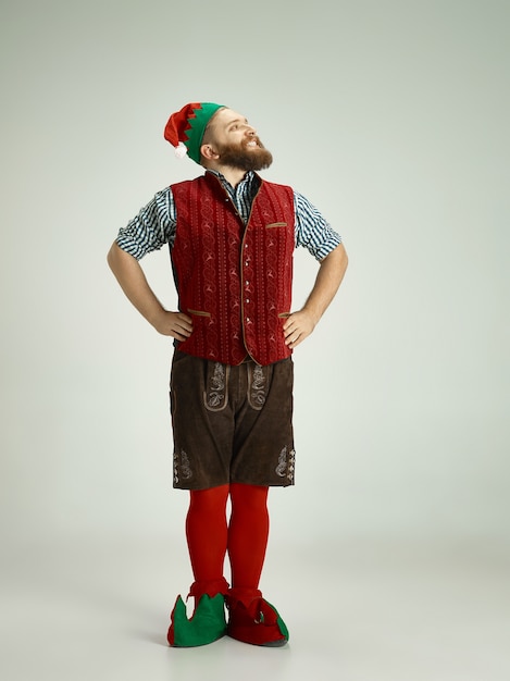 Free Photo friendly man dressed like a funny gnome posing on an isolated gray