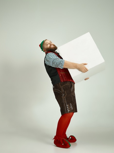 Friendly man dressed like a funny gnome posing on an isolated gray