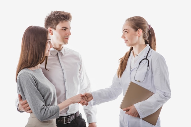 Friendly medic handshaking with couple