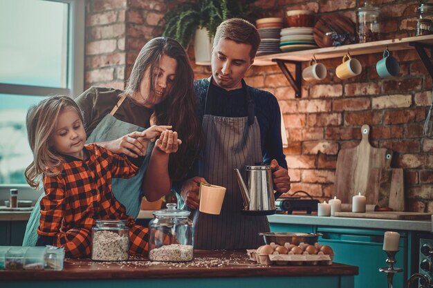 Friendly positive family spending morning at the kitchen, they are cooking breakfast.