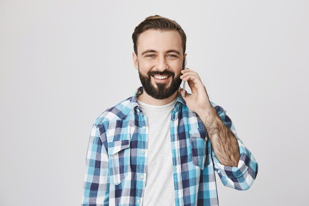 Friendly smiling adult man talking on phone