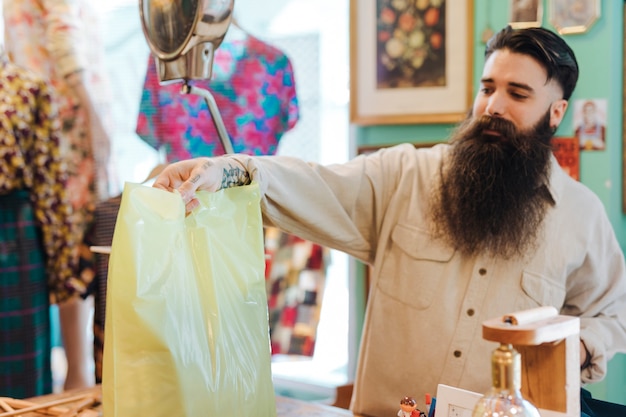 Friendly store clerk hands a customer his bag in the clothing shop