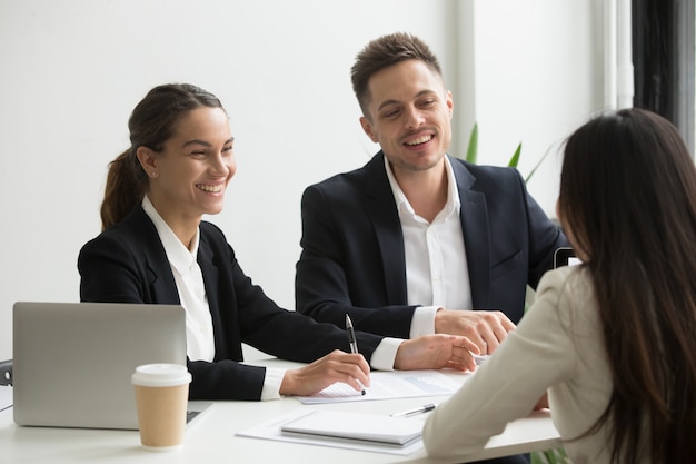 Friendly team members chatting laughing together during office break