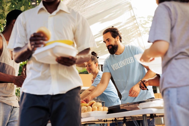 Free photo friendly volunteers at food drive, busy sorting and packing food donations for distribution, embodying the spirit of giving to combat hunger. less privileged, homeless people receive humanitarian aid.