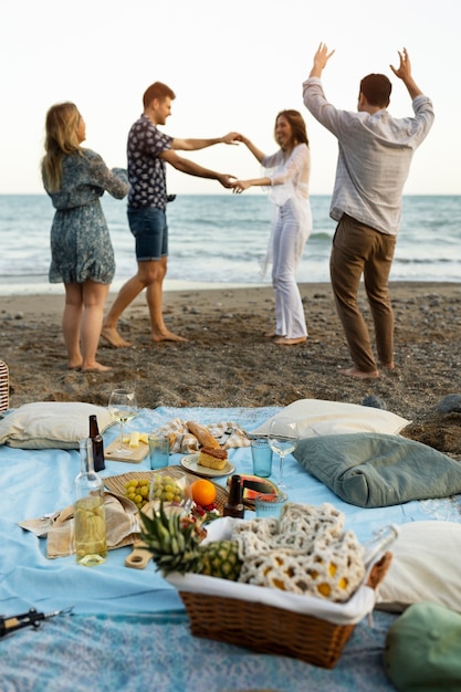 Friends at the beach dancing together during party