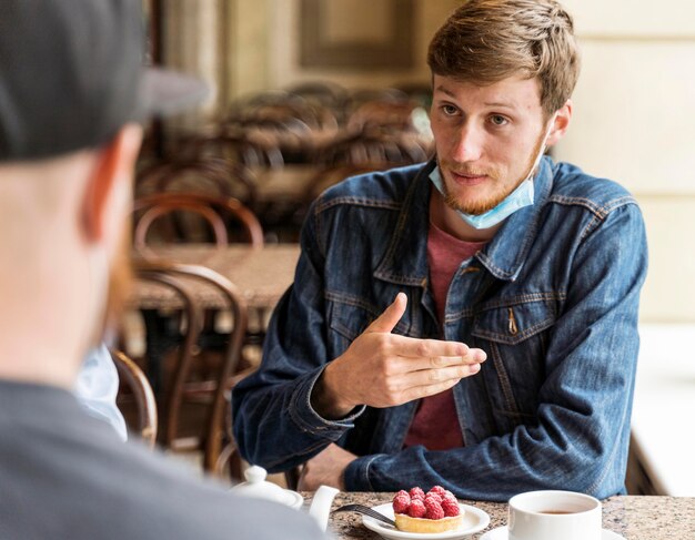 Friends chatting at the restaurant with face masks