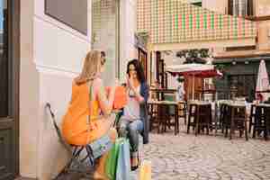 Free photo friends in coffee shop with bags