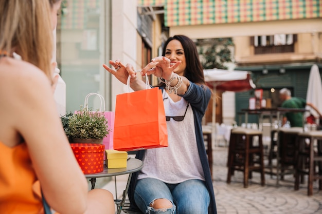 Free photo friends in coffee shop with orange bag