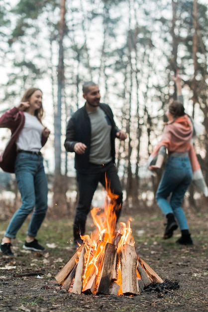 Friends dancing around bonfire