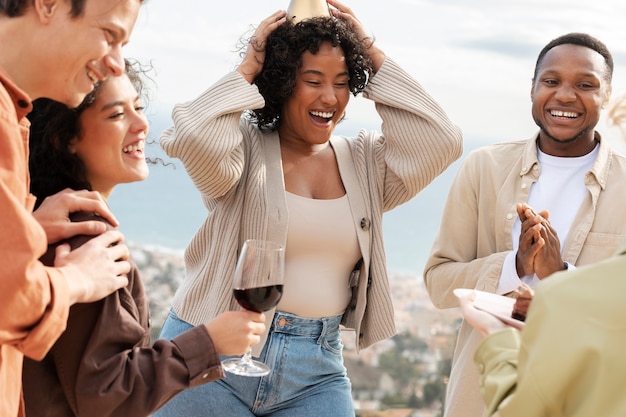 Friends drinking wine and eating cake during outdoor party