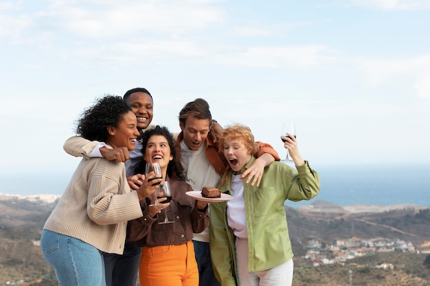 Friends drinking wine and eating cake during outdoor party