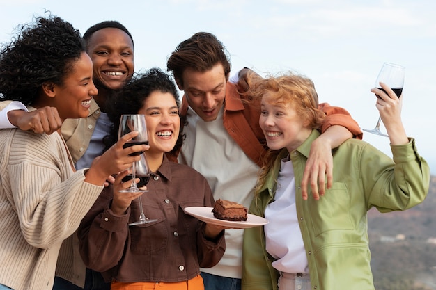 Friends drinking wine and posing during outdoor party