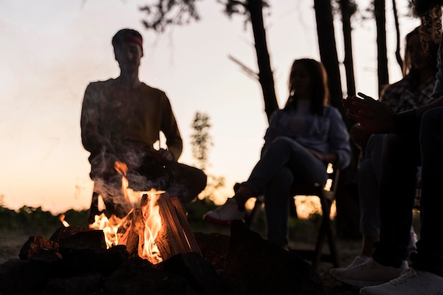 Free Photo friends at dusk gathering around a fire