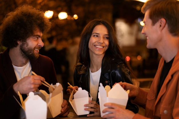 Friends eating chinese food together during a night out