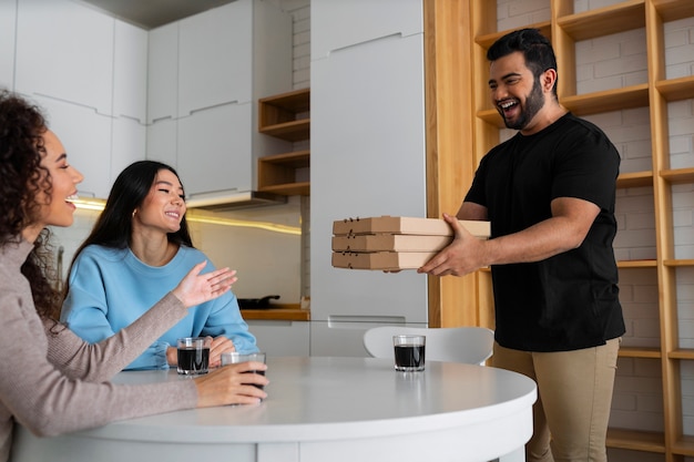 Friends eating pizza at home together