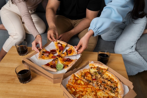 Free photo friends eating pizza together at home