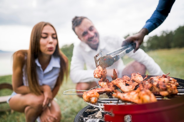 Friends enjoying the meat getting roasted on barbecue