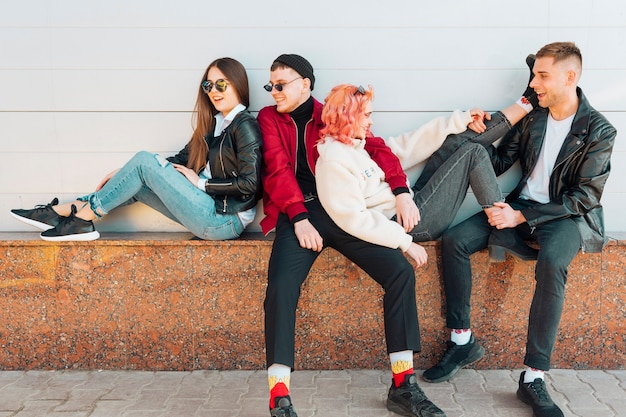 Free photo friends having fun while leaning on street bench