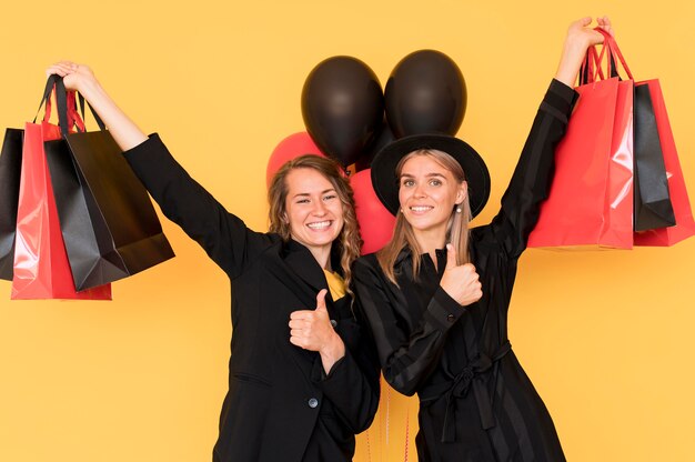 Friends holding black and red bags