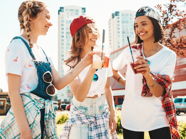 Free photo friends holding and drinking fresh cocktail smoothie drink in plastic cup with straw