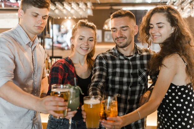 Friends holding glasses of drinks celebrating together