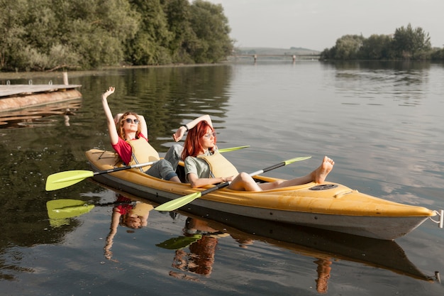 Free photo friends in kayak laying in the sun