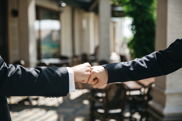 Friends knock hands at the wedding ceremony