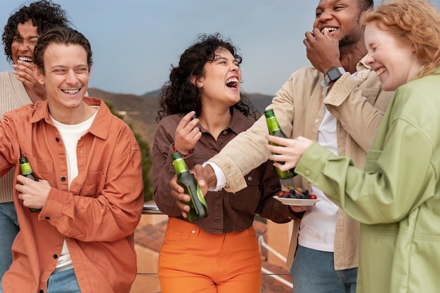 Friends laughing and drinking beer during outdoor party