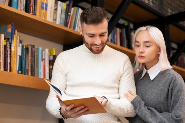 Free Photo friends looking at book in a library