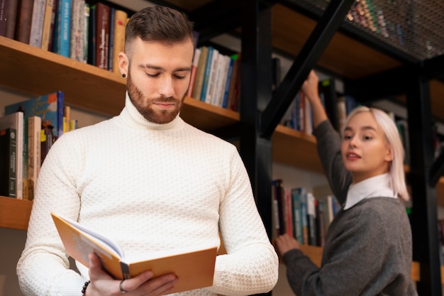 Friends looking at book in a library