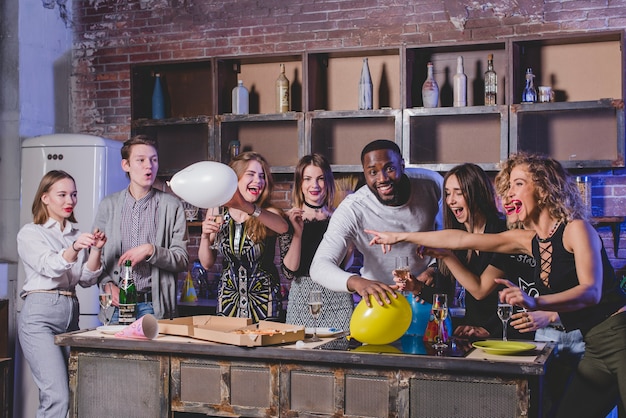 Friends looking at camera on kitchen