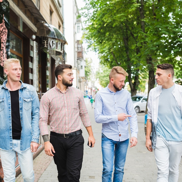 Friends looking at man pointing finger at outdoors