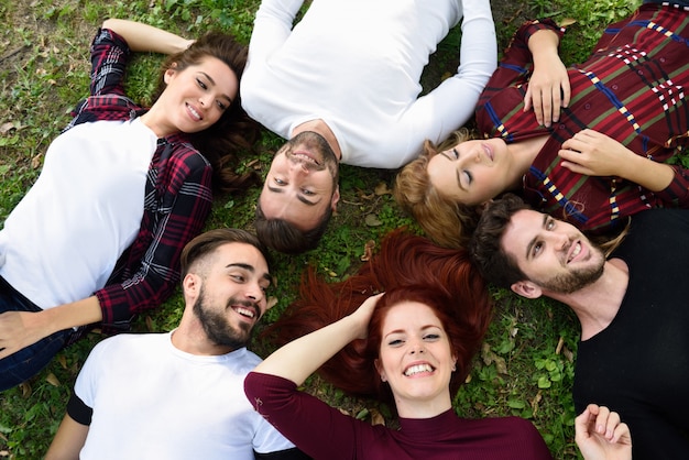 Friends lying on the lawn face up in a park