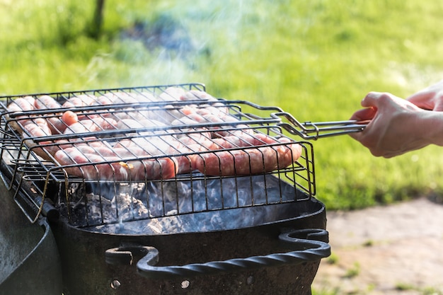 Friends making barbecue and having lunch in the nature.