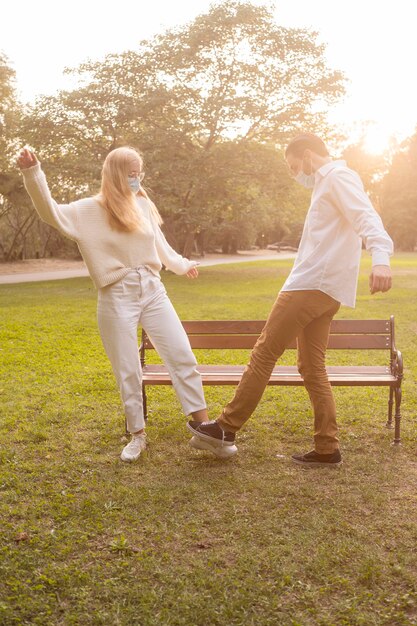 Friends at the park practicing social distance salute