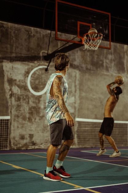 Friends play basketball. Young men play basketball in the street.