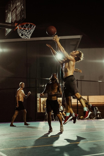 Friends play basketball. Young men play basketball in the street.