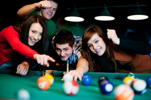 Free photo friends playing billiard