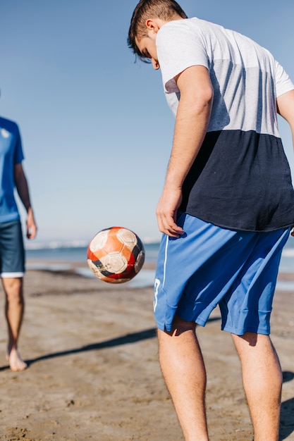 Free Photo friends playing football at the beach