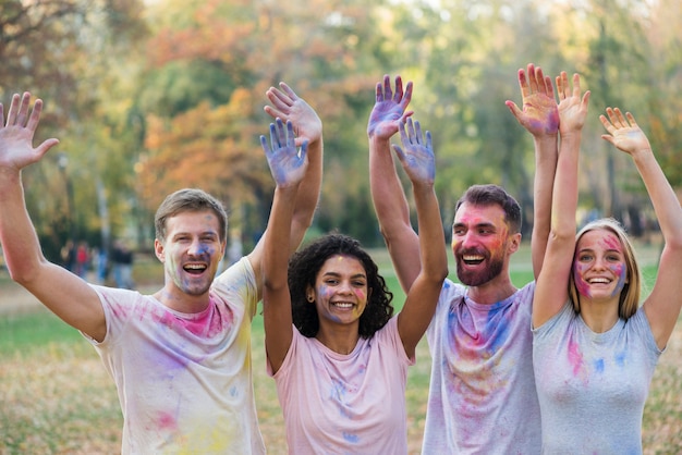 Friends posing while holding colored hands in the air