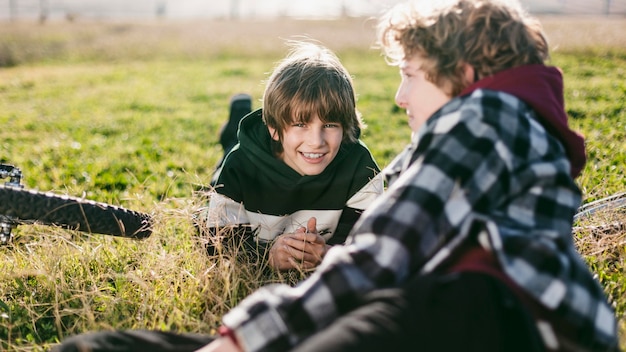 Friends resting on grass while riding their bikes