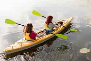 Free photo friends rowing in kayak on lake