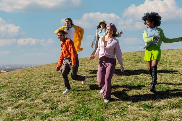 Friends running down the hill in an outdoor field