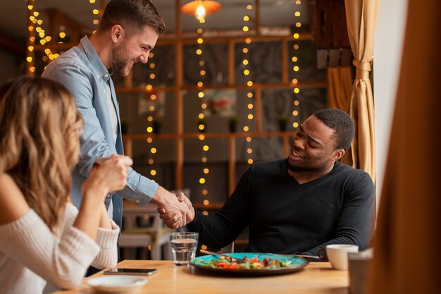 Friends shaking hands at restaurant