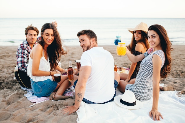 Free photo friends sitting at the beach