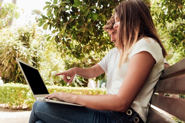 Free Photo friends sitting on bench with a notebook