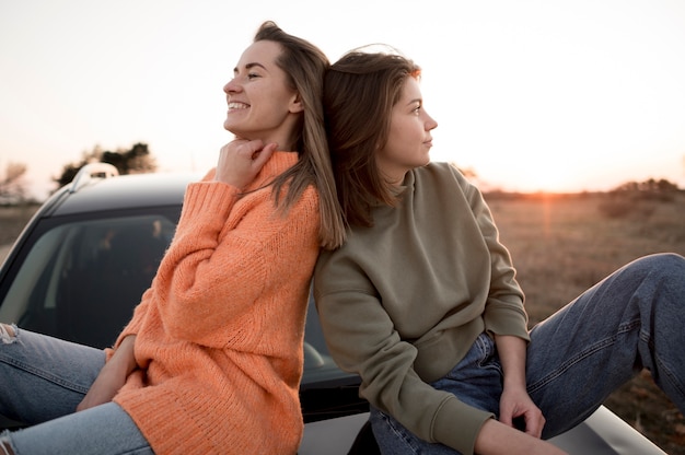 Free Photo friends sitting on a car