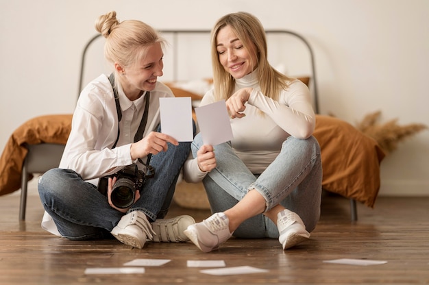 Friends sitting on the floor and looking at photos