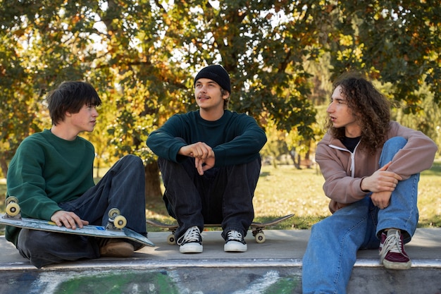 Friends sitting in skatepark front view